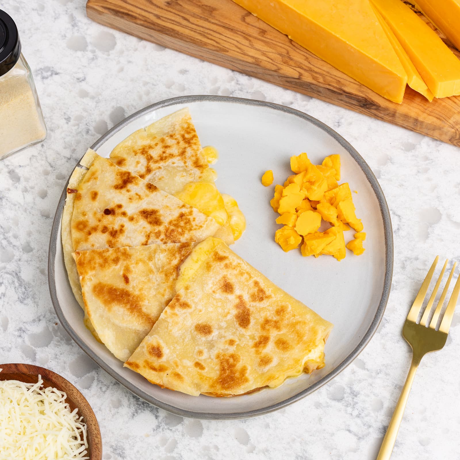 Rise & Puff High Protein Quesadilla with pieces of cheese and meat next to it.