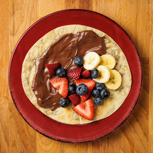 Strawberry, mixed berry, and banana chocolate dessert wrap made with Rise & Puff tortillas