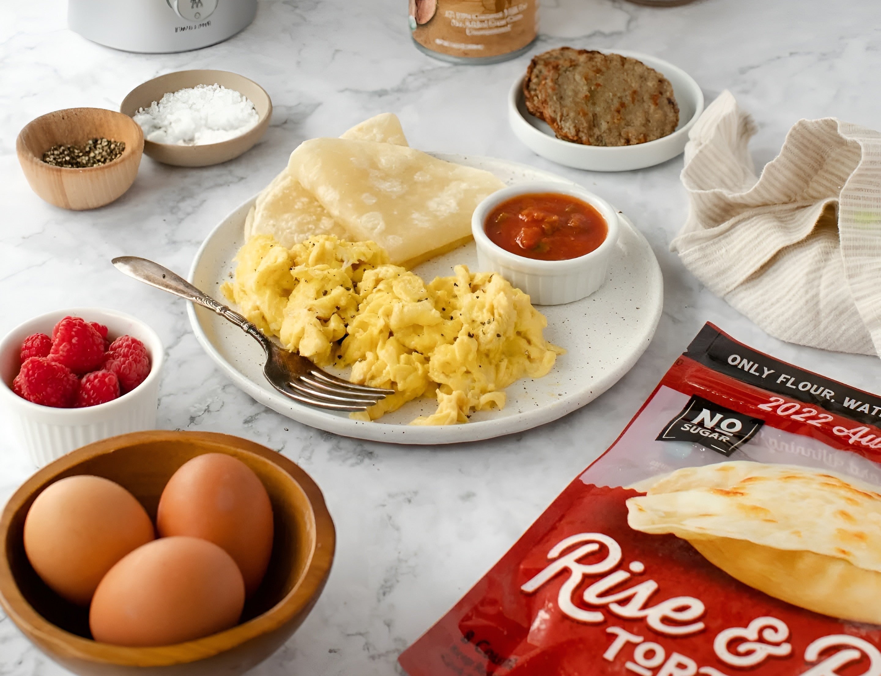 Soft scrambled eggs served with warm tortillas and salsa, made with Rise & Puff tortillas for a cozy breakfast.