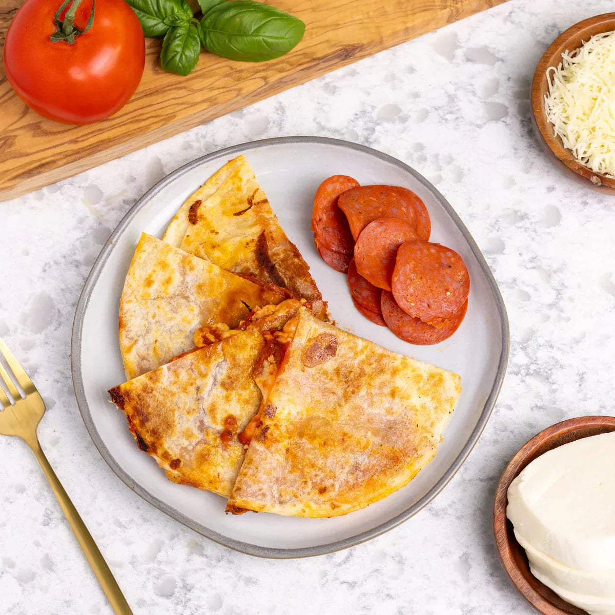 A plate of pizza quesadilla from Rise & Puff, served with cheese on the side.
