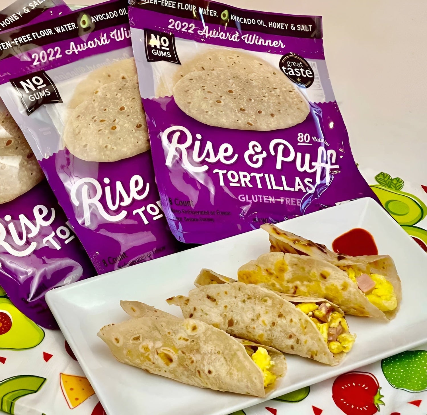 Tacos made with Rise & Puff tortillas, served on a white plate with tortilla packs in the background.