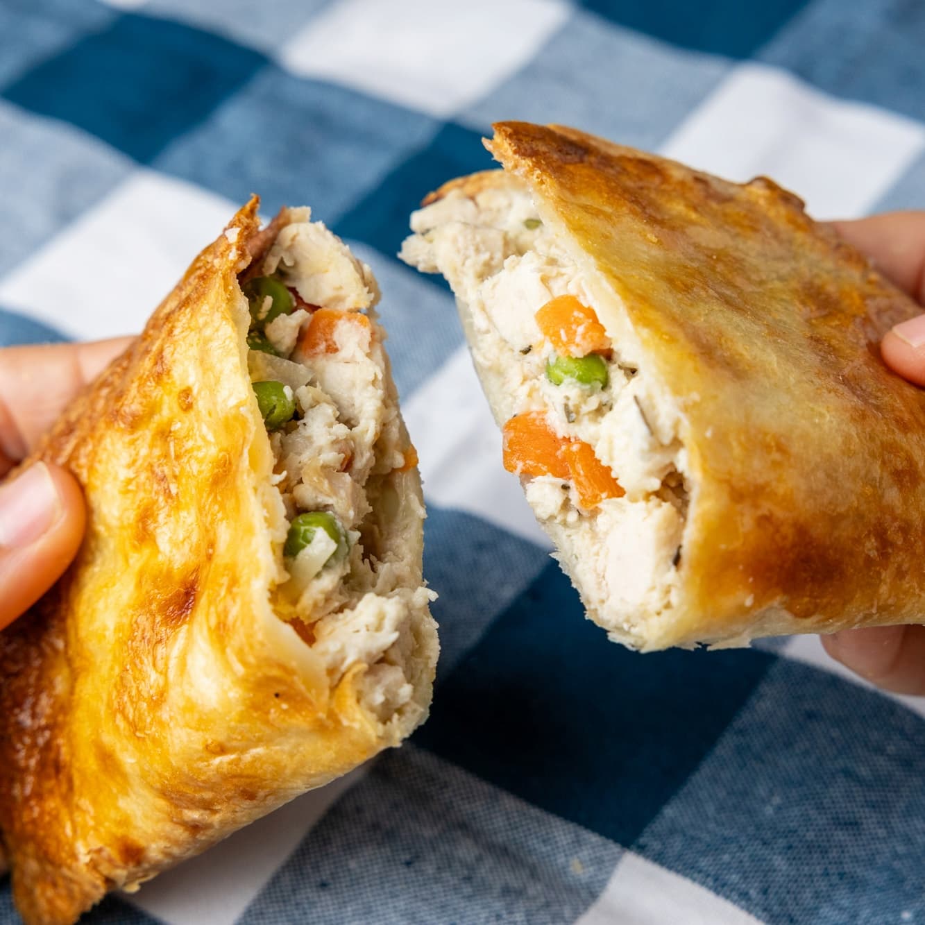 Chicken pot pie with view of filling inside containing fresh white-meat chicken, peas, and carrots