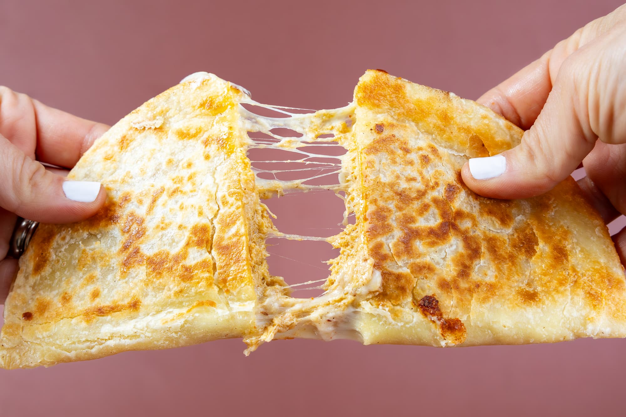 Chipotle Chicken quesadilla cut in half being pulled apart