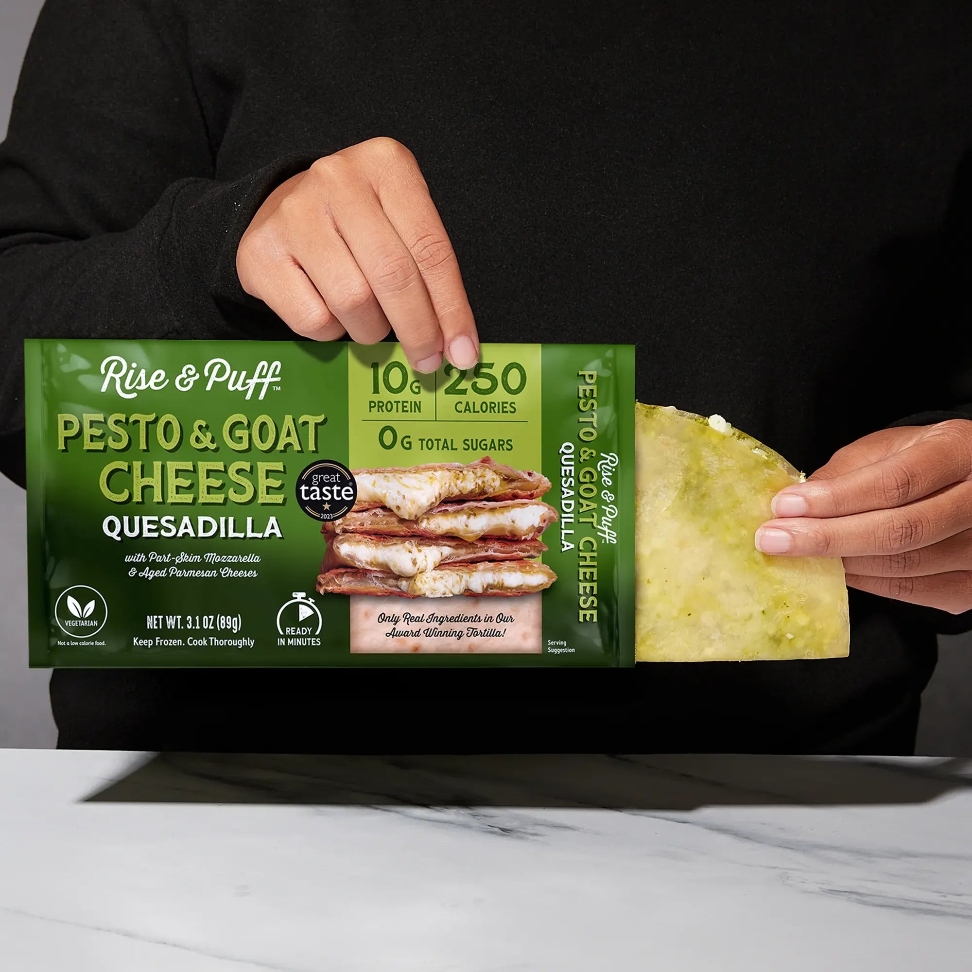 Rise & Puff Pesto & Goat Cheese Quesadilla shown coming out of its frozen retail packaging