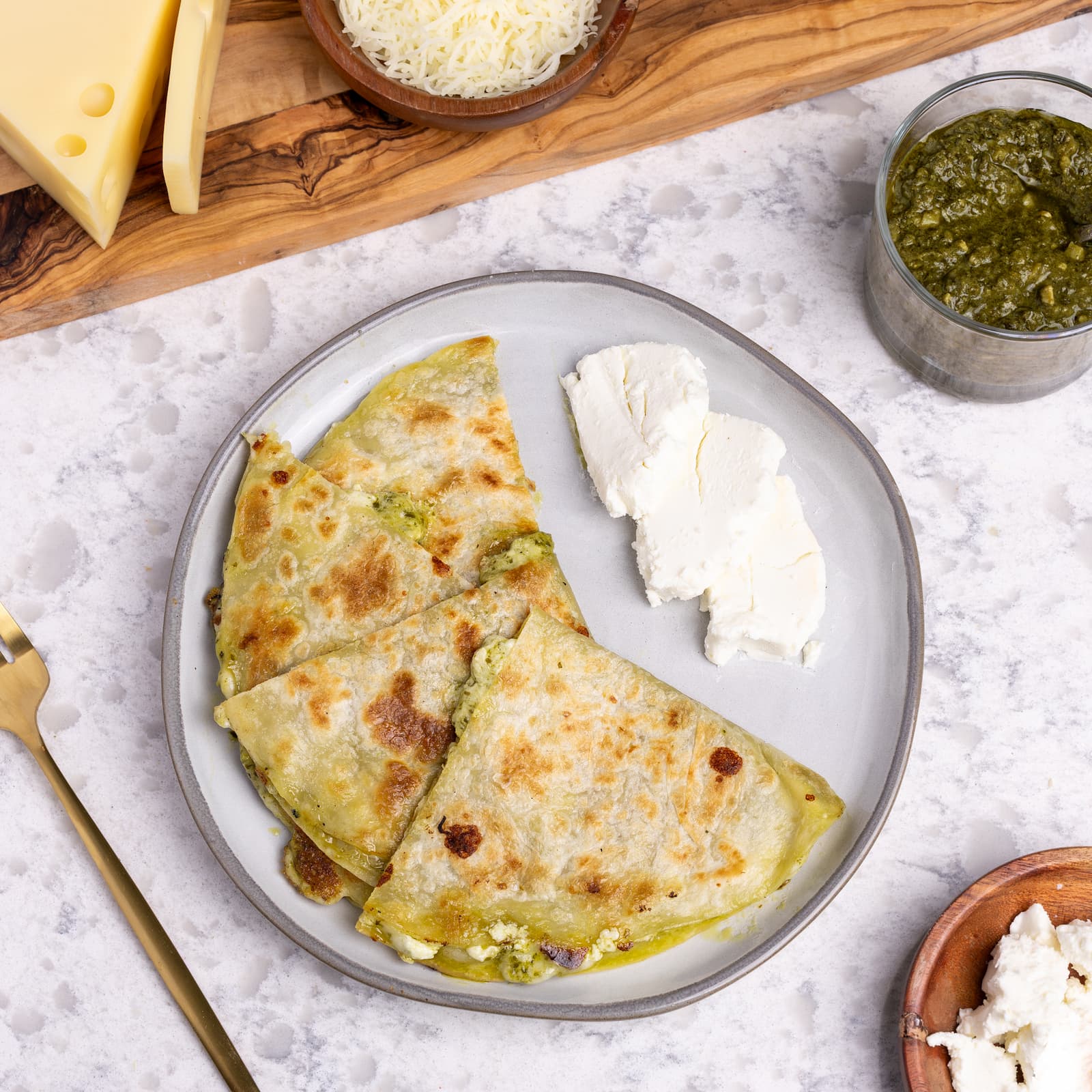 healthy pesto and goat cheese quesadilla with ingredients on plate