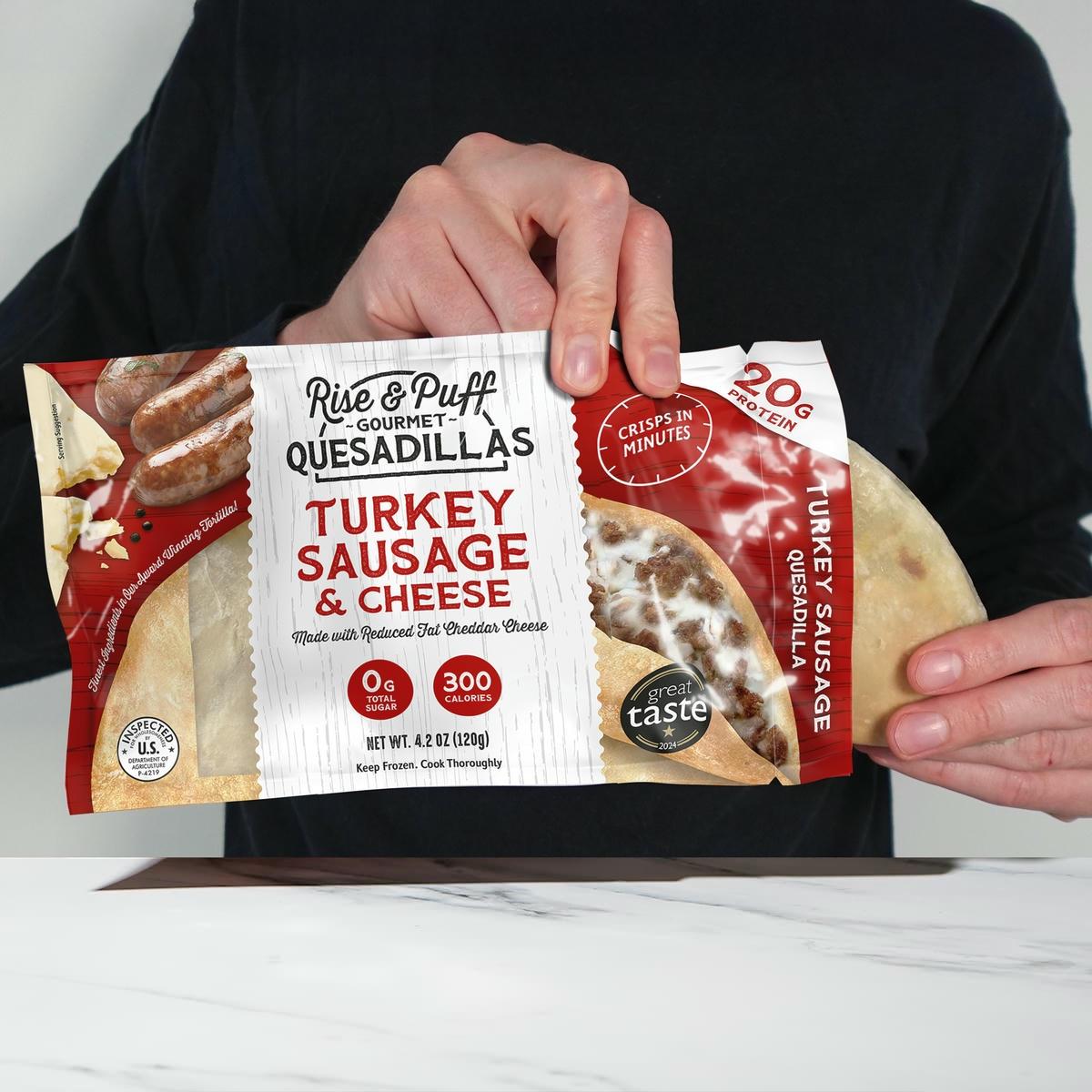 Person holding a package of Rise & Puff Gourmet Quesadillas Turkey Sausage & Cheese flavor.