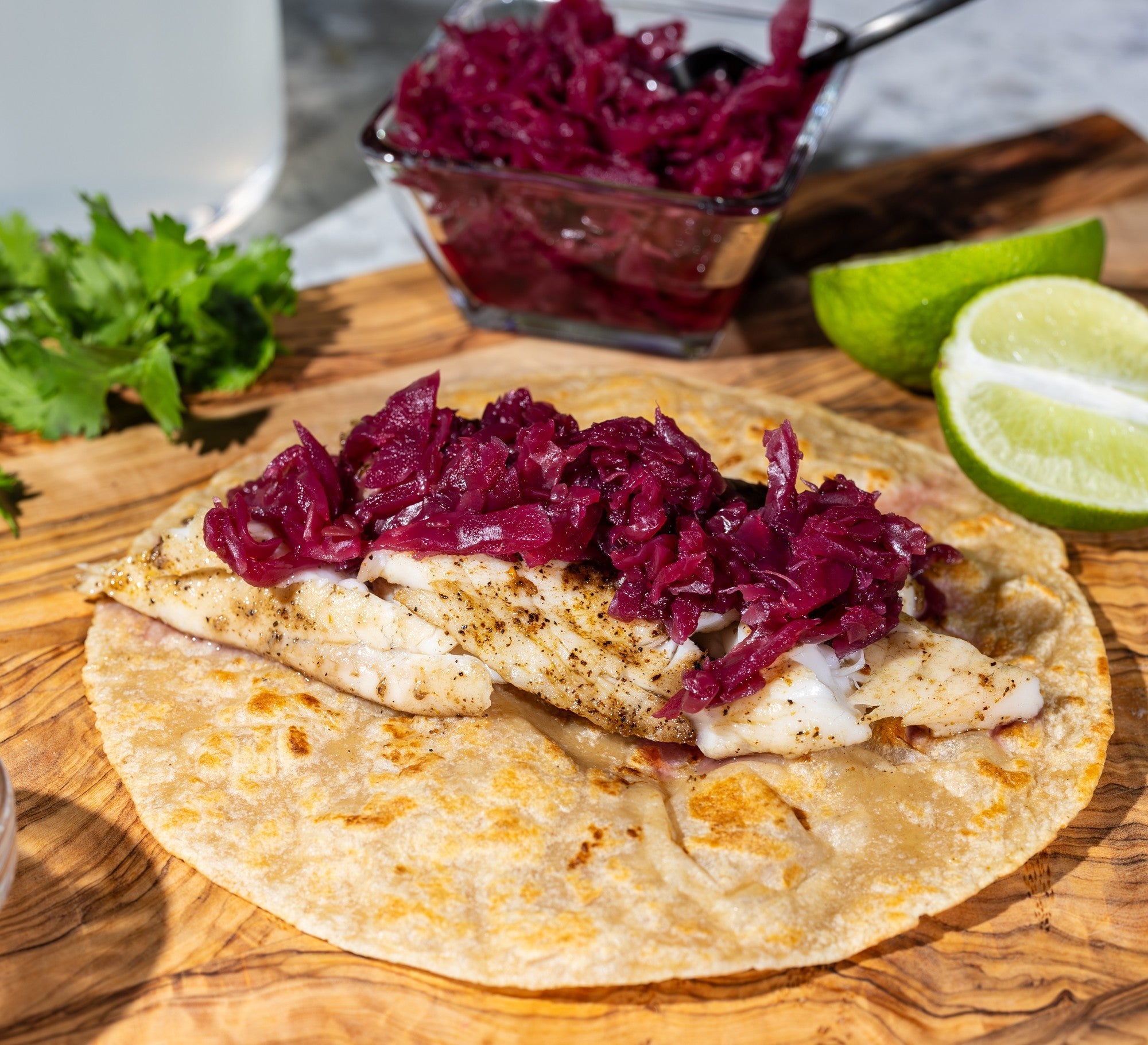 Grilled fish quesadilla topped with pickled red cabbage on a golden tortilla, served fresh by Rise & Puff.