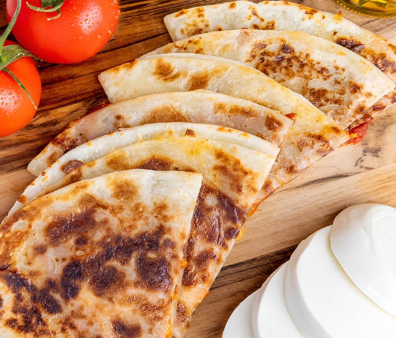  Rise and Puff Margherita quesadillas with golden crust, mozzarella slices, and fresh tomatoes on a wooden board.