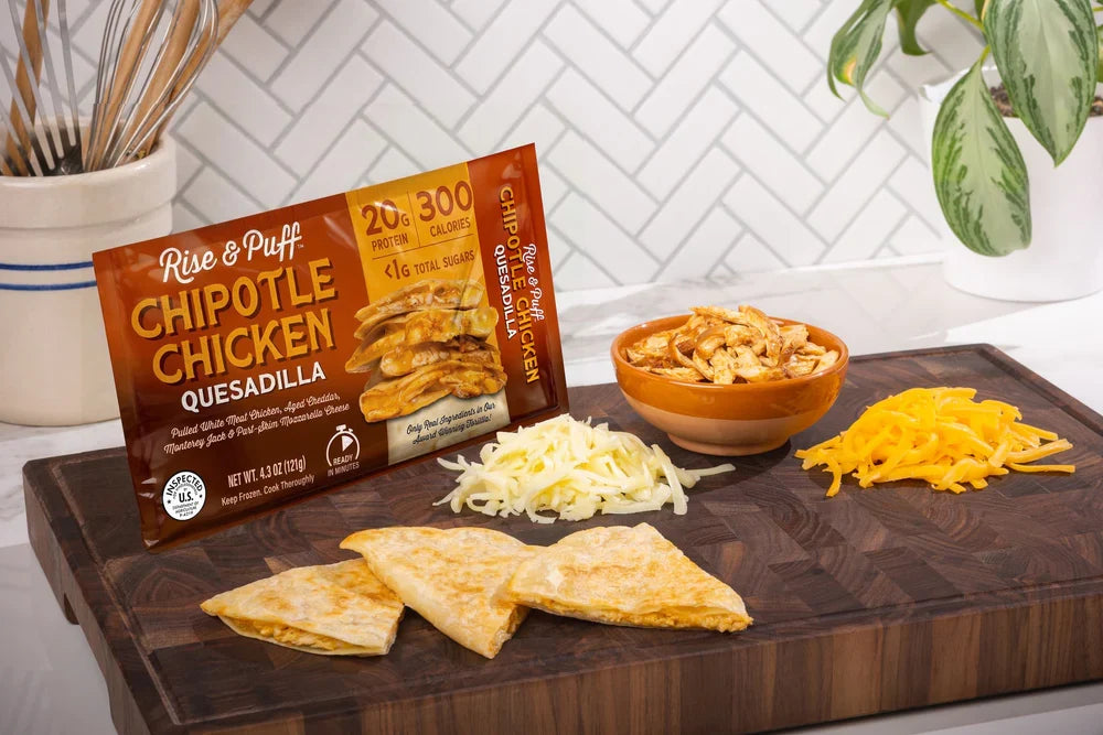 Rise & Puff quesadilla in its packaging, placed on a wooden tray, ready to cook.