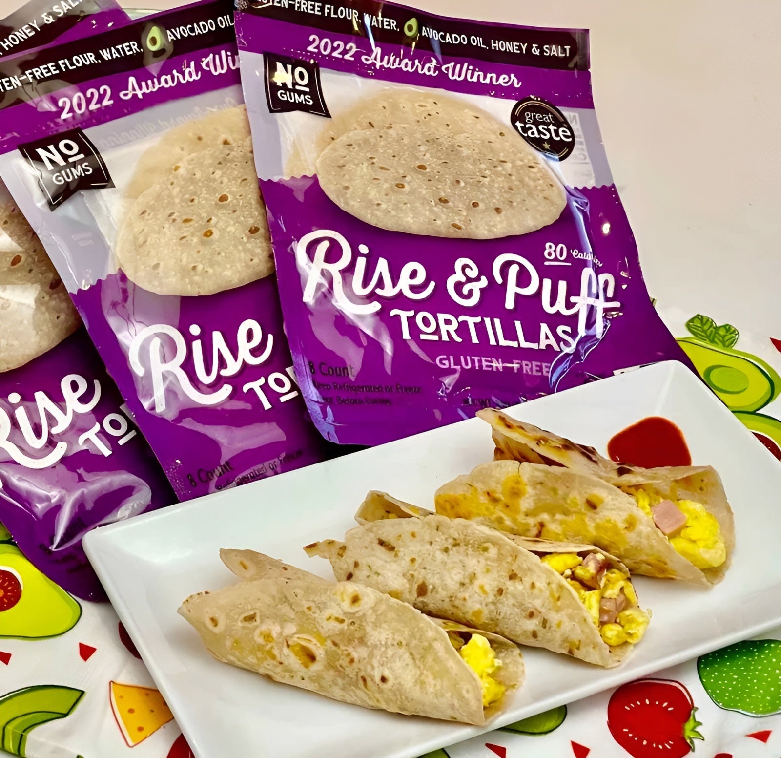 Tacos made with Rise & Puff tortillas, served on a white plate with tortilla packs in the background.