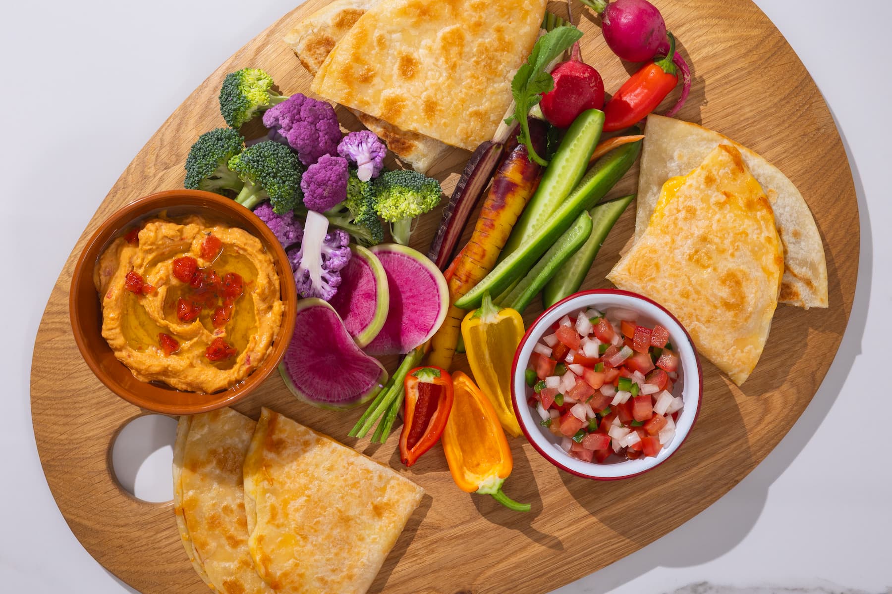 Quesadillas on cutting board with fresh veggies