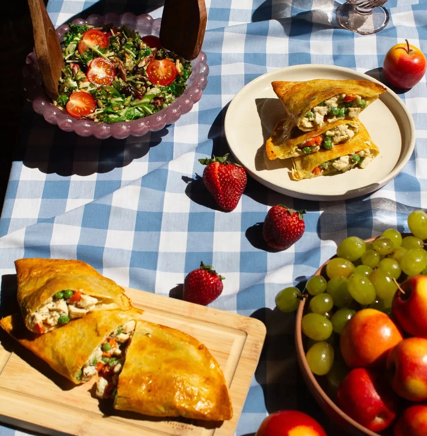 Chicken Pot Pie on picnic table with salad and fruit