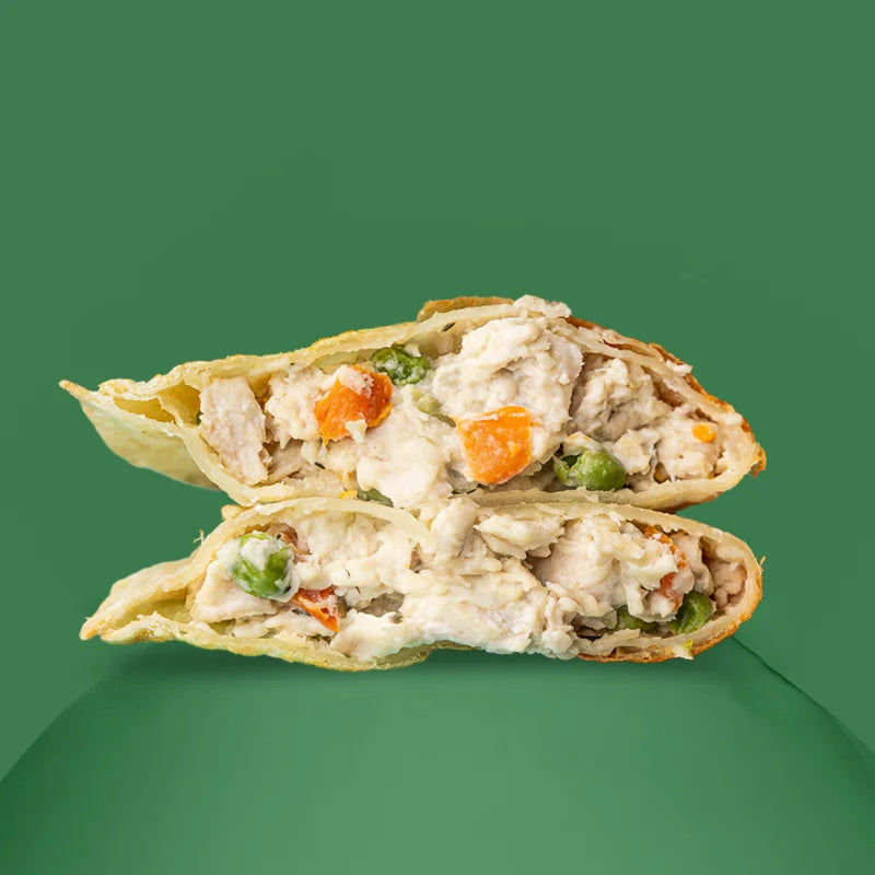 Chicken pot pie with view of filling inside containing fresh white-meat chicken, peas, and carrots